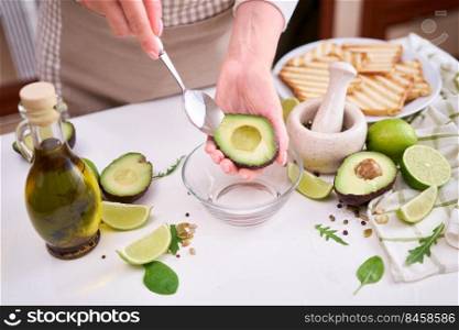 Making avocado toast - Woman peeling ripe halved avocado.. Making avocado toast - Woman peeling ripe halved avocado