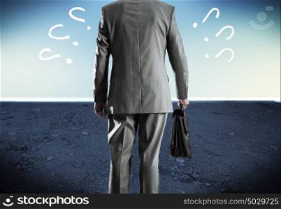 Making choice. Bottom view of businessman with suitcase in hand