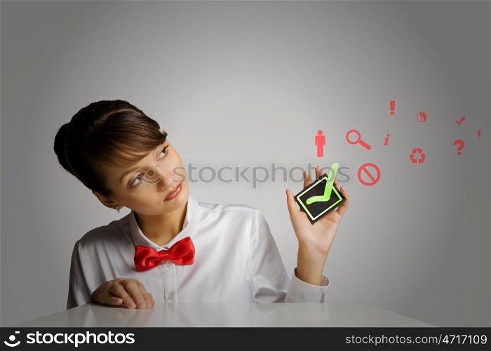 Making choice. Young woman holding black card with tick