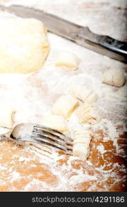 making fresh Italian potato gnocchi on a wood rustic table