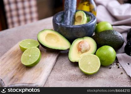 making guacamole - fresh sliced avocado in marble mortar on grey concrete table.. making guacamole - fresh sliced avocado in marble mortar on grey concrete table