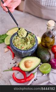 making guacamole - woman holding spoon with mixed minced ingredients.. making guacamole - woman holding spoon with mixed minced ingredients
