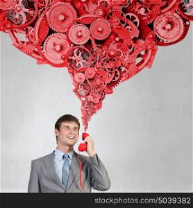 Making important calls. Smiling businessman talking on red phone handset