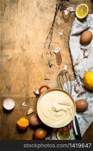 Making mayonnaise from eggs, garlic and lemon. On wooden background.. Making mayonnaise from eggs, garlic and lemon.