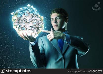 Making money. Businessman holding ball of money in hand