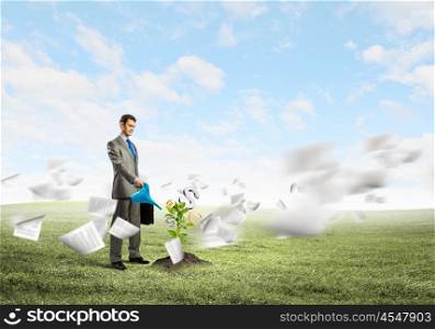 Making money. Image of businessman watering money tree with currency symbols