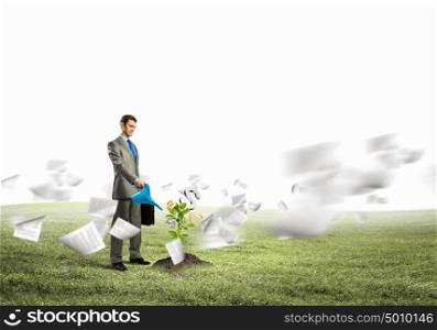 Making money. Image of businessman watering money tree with currency symbols