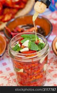 Making of dried tomatoes with garlic, oil and mint