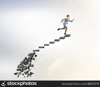 Making risky steps. Businesswoman climbs steps of collapsing finance ladder