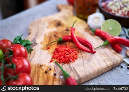 making salsa dip sauce - sliced and chopped chili pepper on wooden cutting board.. making salsa dip sauce - sliced and chopped chili pepper on wooden cutting board