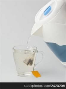 making tea with hot water from electric kettle