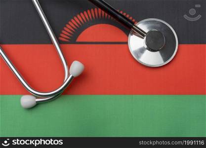 Malawi flag and stethoscope. The concept of medicine. Stethoscope on the flag as a background.. Malawi flag and stethoscope. The concept of medicine.