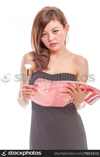 Malay woman in black dress putting on makeup holding pink cosmetics bag