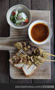 Malaysian food chicken satay with peanut sauce on wood background