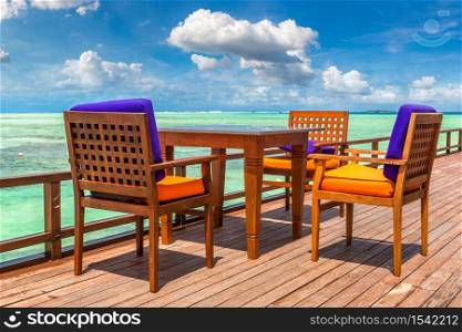 MALDIVES - JUNE 24, 2018: Table and chairs at tropical beach restaurant in the Maldives at summer day