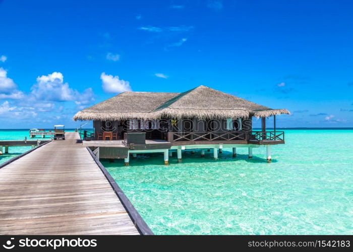 MALDIVES - JUNE 24, 2018: Water Villas (Bungalows) and wooden bridge at Tropical beach in the Maldives at summer day