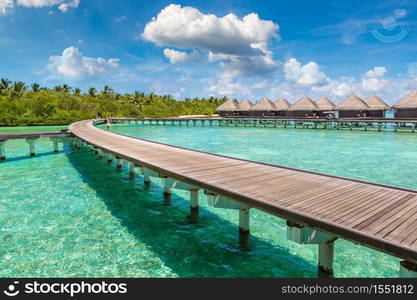 MALDIVES - JUNE 24, 2018: Water Villas (Bungalows) and wooden bridge at Tropical beach in the Maldives at summer day