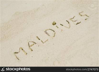 Maldives note written on a white sandy beach