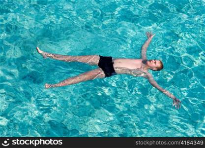Maldives. Teenager has a rest on turquoise transparent water of ocean
