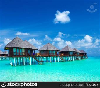 Maldives water bungalows resort at islands beach. Indian Ocean, Maldives. Beautiful sea landscape, luxury resort and sky. Beach under wonderful sky
