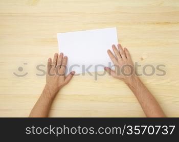 male&acute;s hand holds a blank paper