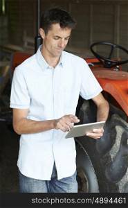Male Agricultural Worker Looking At Digital Tablet