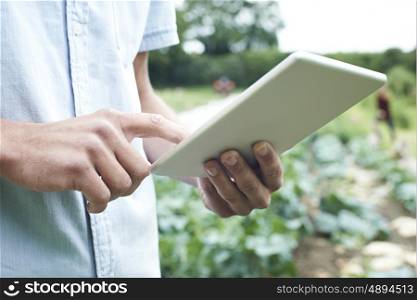 Male Agricultural Worker Using Digital Tablet In Field