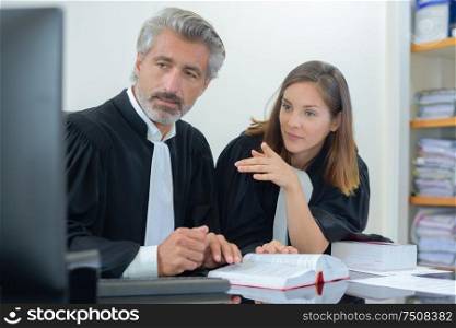 Male and female barristers looking at computer screen