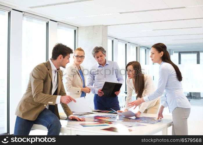 Male and female design professionals having discussion at table in new office