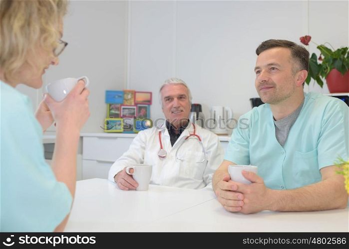 male and female doctors talking to nurse on work break