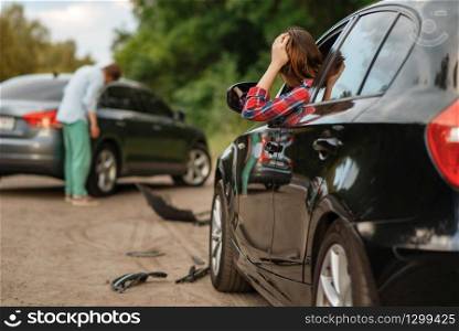 Male and female drivers after car accident on road. Automobile crash. Broken automobile or damaged vehicle, auto collision on highway. Male and female drivers after car accident on road