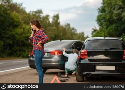 Male and female drivers on road, car accident. Automobile crash. Broken automobile or damaged vehicle, auto collision on highway. Male and female drivers on road, car accident