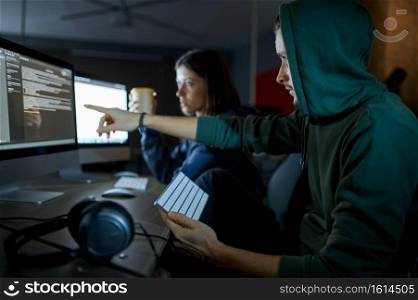 Male and female hackers works on computers in darknet, dangerous teamwork. Illegal web programmer at workplace, criminal occupation. Data hacking, cyber security. Male and female hackers works in darknet