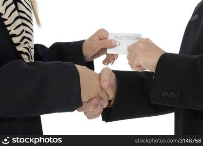 Male and female hands shaking and passing plantinum credit card.