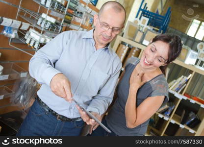 male and female holding tablet computer