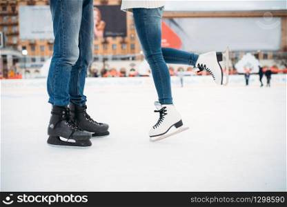 Male and female legs in skates, love couple on the rink. Winter skating on open air, active leisure, ice-skating