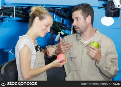 male and female manual workers eating apple for lunch