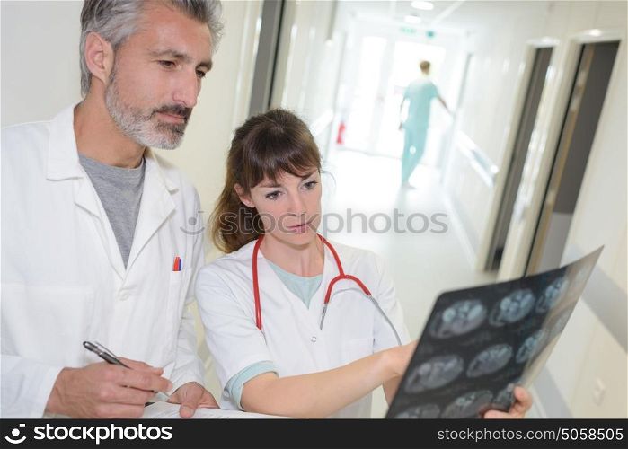 Male and female medical workers looking at xray