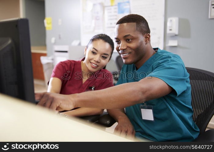 Male And Female Nurse Working At Nurses Station