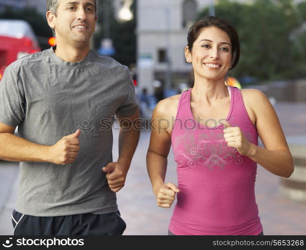 Male And Female Runners On Urban Street