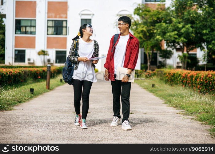 Male and female students wear a face Chill and stand in front of the university.