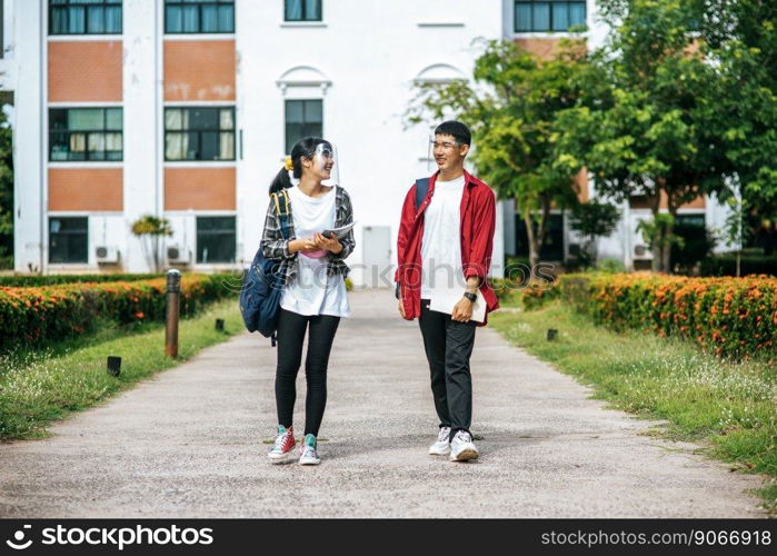 Male and female students wear a face Chill and stand in front of the university.