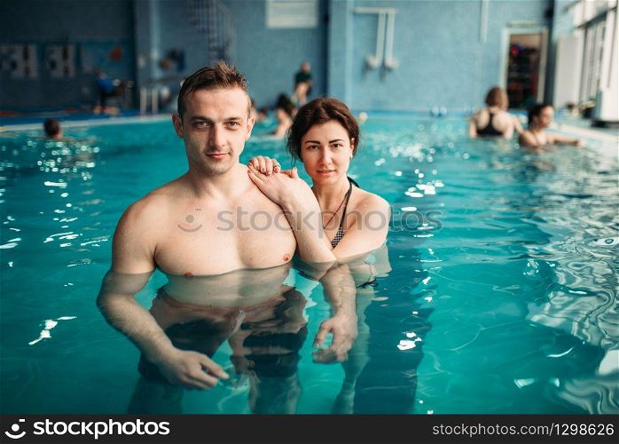 Male and female swimmers, leisure in swimming pool. Aqua aerobics training, water sport and healthy lifestyle