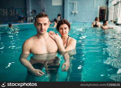 Male and female swimmers, leisure in swimming pool. Aqua aerobics training, water sport and healthy lifestyle