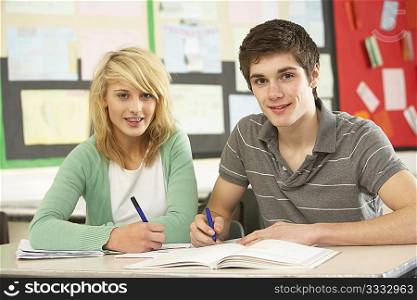 Male And Female Teenage Students Studying In Classroom