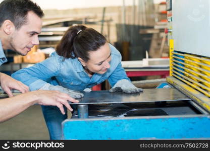 male and female workers in metalworks factory