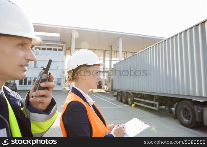 Male and female workers working in shipping yard