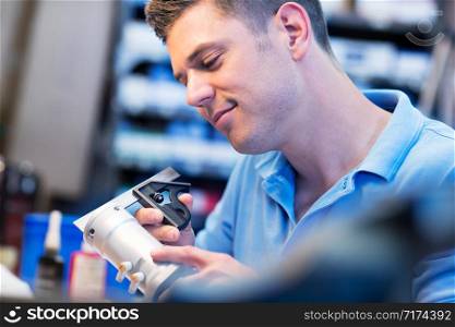 Male Apprentice Measuring Component In Factory