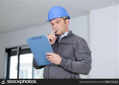 male architect holding clipboard indoors
