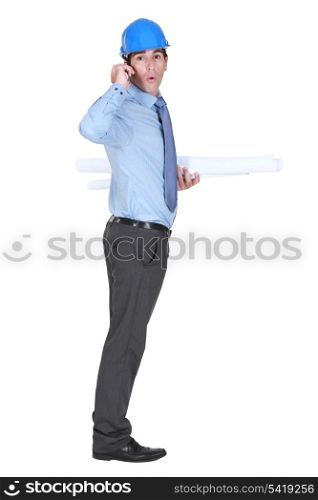 male architect on the phone holding blueprints